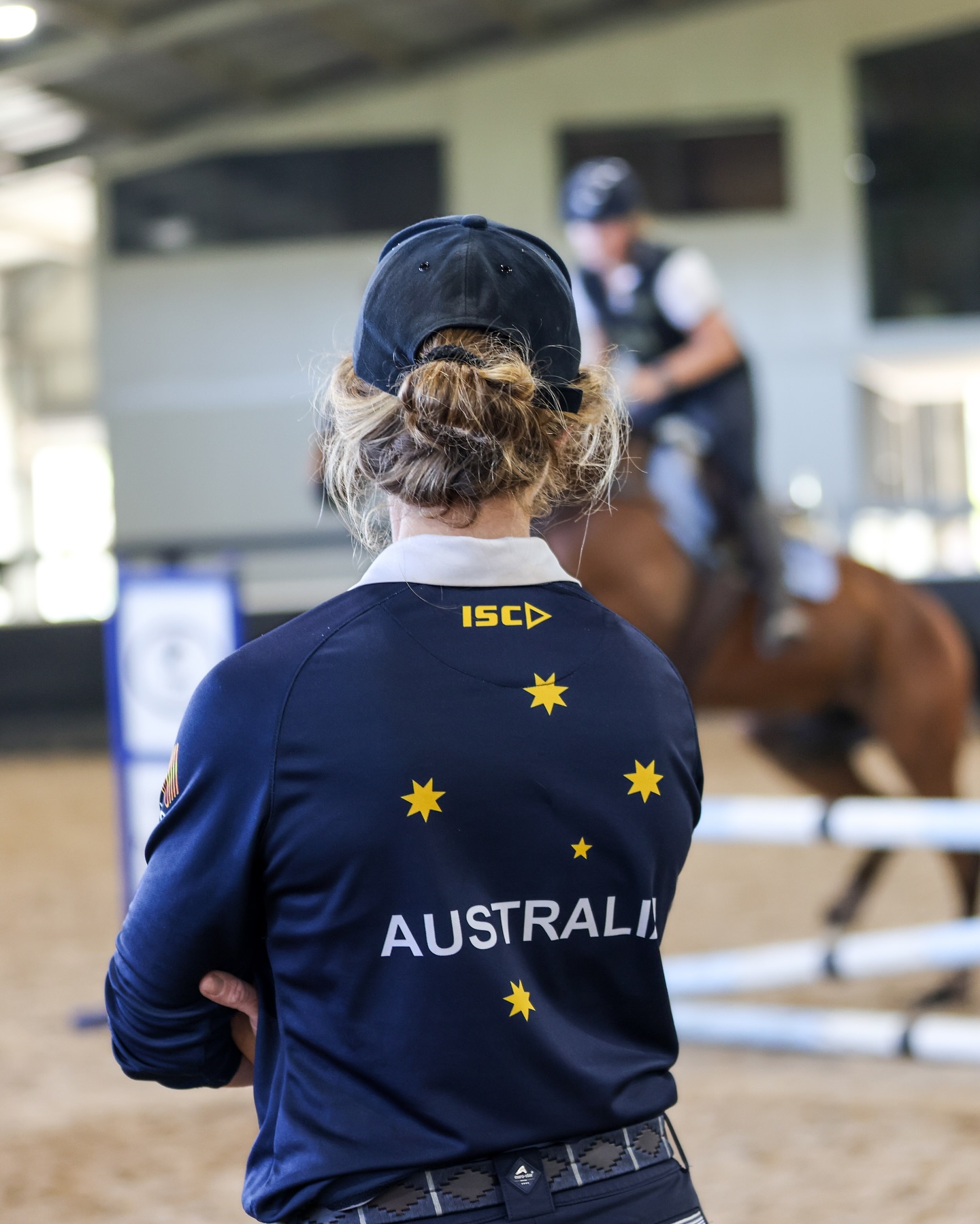 Hazel Shannon coaching a rider in an arena